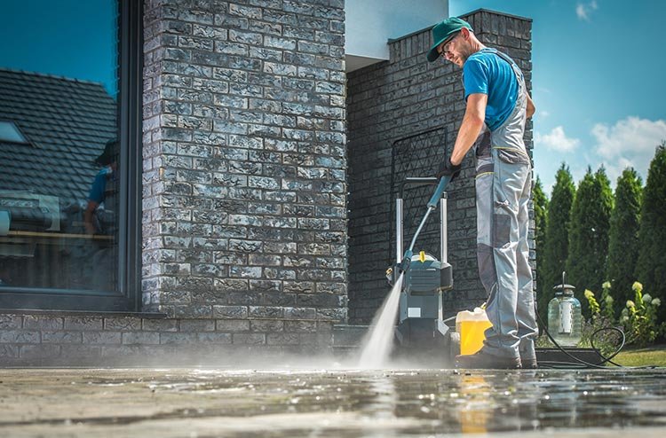 man pressure washing the floor