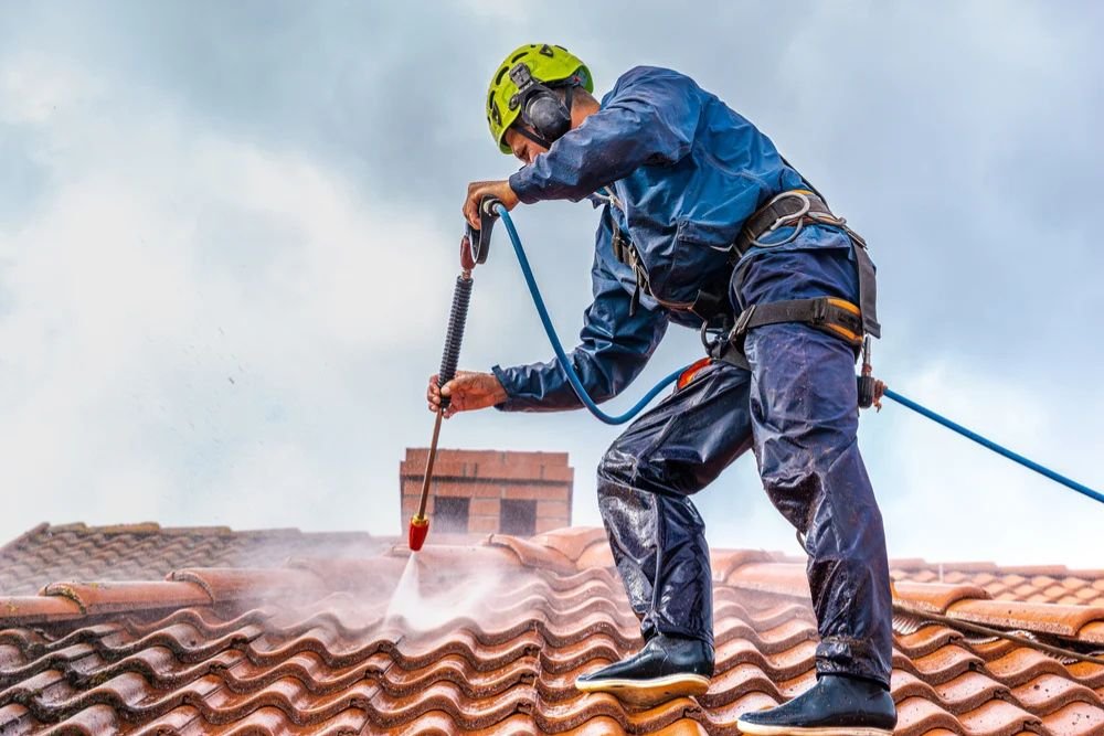 a man on a roof cleaning